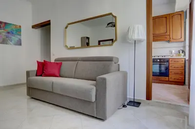 a living room with a couch and a mirror at Vatican Apt Doria 64 - Home and More in Rome