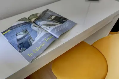 a magazine on a shelf next to two oranges at Vatican Apt Doria 64 - Home and More in Rome