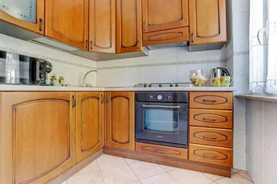 a kitchen with wooden cabinets and a black oven at Vatican Apt Doria 64 - Home and More in Rome
