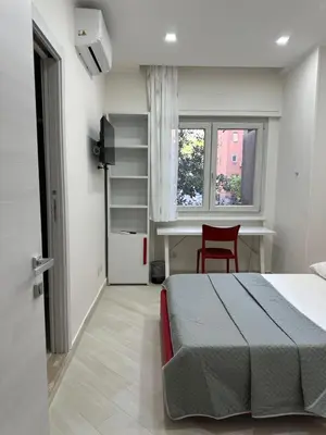 a bedroom with a bed and a desk and a window at BALDO 352 HOME in Rome