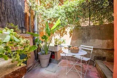a patio with a table and chairs and plants at Domus Fori Imperiali in Rome