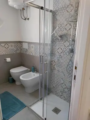 a bathroom with a toilet and a glass shower at Ponentino B&B in Rome