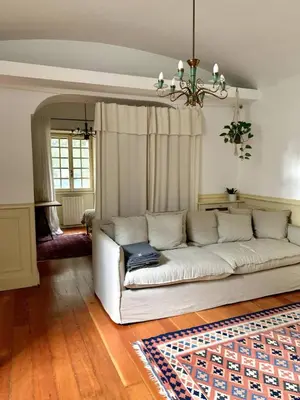 a white couch in a living room with a rug at Giardino dei Giganti, 5 minute walk to the subway B in Rome
