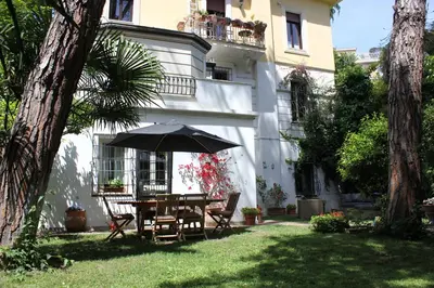 a table and chairs with an umbrella in front of a building at Giardino dei Giganti, 5 minute walk to the subway B in Rome