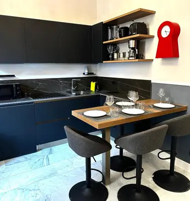a kitchen with a wooden table and two chairs at Via Veneto Luxury House in Rome
