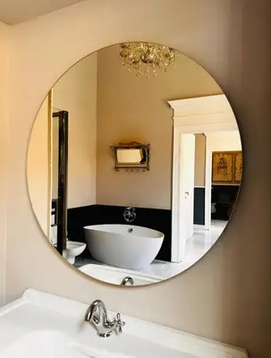 a bathroom with a tub and a round mirror at Via Veneto Luxury House in Rome
