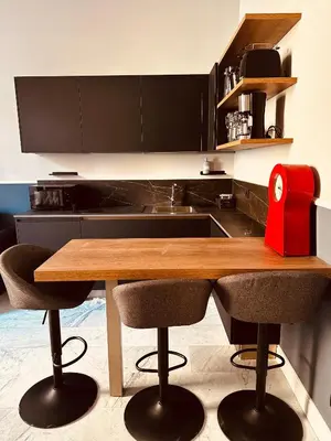a kitchen with a wooden table and some chairs at Via Veneto Luxury House in Rome