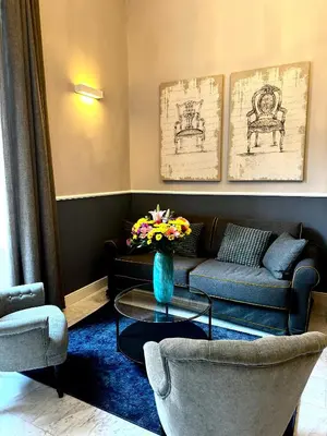 a living room with a couch and a table with flowers at Via Veneto Luxury House in Rome