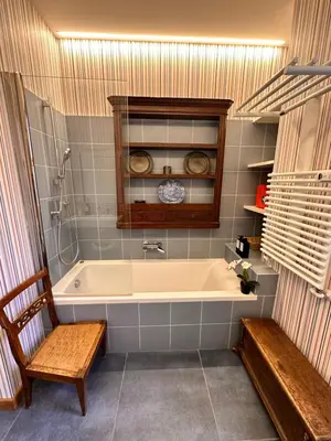 a bath tub in a bathroom with a bench at Appartamento Coppedè in Rome