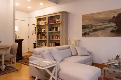 a living room with a couch and a book shelf at Appartamento Coppedè in Rome