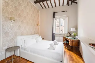 a bedroom with a white bed and a desk at Gn Suite Oro in Rome