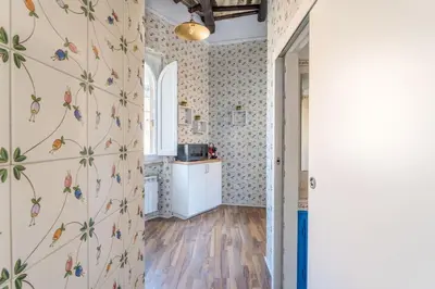 a kitchen with a wall with floral wallpaper at Gn Suite Oro in Rome