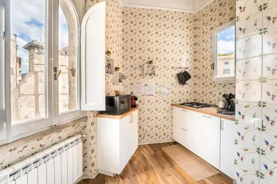 a kitchen with white cabinets and a window at Gn Suite Oro in Rome
