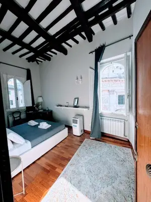 a bedroom with a bed and a large window at Gn Suite Oro in Rome