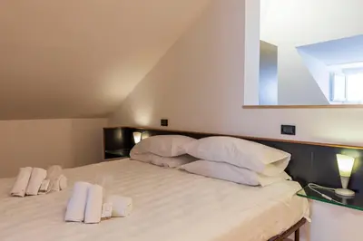 a bedroom with a large bed with white sheets and pillows at FCR Rome Apartments Ponte Milvio - Fleming in Rome