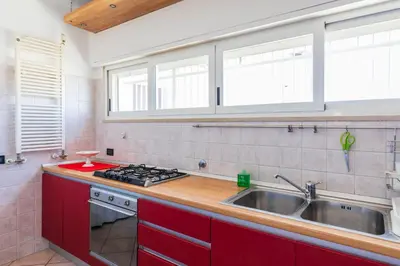 a kitchen with red cabinets and a sink at FCR Rome Apartments Ponte Milvio - Fleming in Rome