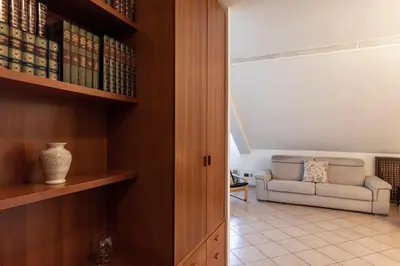 a living room with a couch and a book shelf at FCR Rome Apartments Ponte Milvio - Fleming in Rome