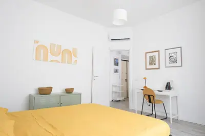 a bedroom with a yellow bed and a desk at Eurialo Roma Design Apartment - MyItalianStay in Rome