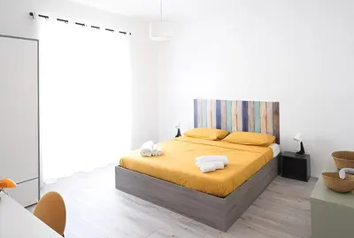a white bedroom with a bed with yellow sheets and towels at Eurialo Roma Design Apartment - MyItalianStay in Rome