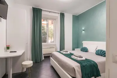 a bedroom with a bed and a desk and a window at San Giovanni apartment in Rome