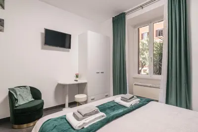 a bedroom with a bed and a chair and a window at San Giovanni apartment in Rome