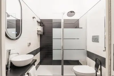 a bathroom with a toilet sink and a shower at San Giovanni apartment in Rome