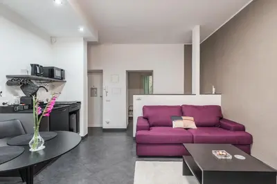 a living room with a purple couch and a table at San Giovanni apartment in Rome