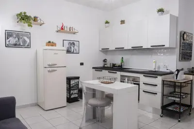 a kitchen with white cabinets and a white refrigerator at Casa Daniela in Rome