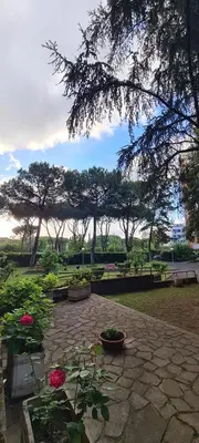 a park with a stone patio with flowers and trees at Rome at Hand in Rome