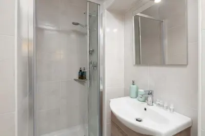 a white bathroom with a shower and a sink at 25 Penthouse Porta Pia in Rome