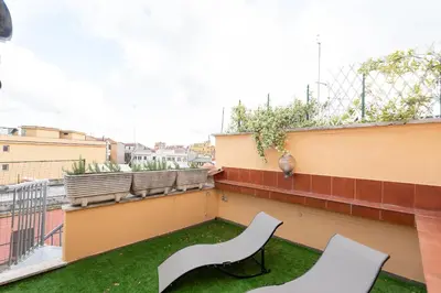 a balcony with two white chairs on a building at 25 Penthouse Porta Pia in Rome