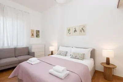 a white bedroom with a bed and a couch at 25 Penthouse Porta Pia in Rome