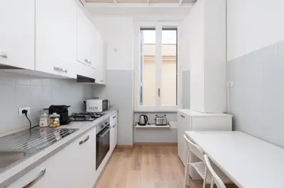 a white kitchen with white cabinets and a counter at 25 Penthouse Porta Pia in Rome