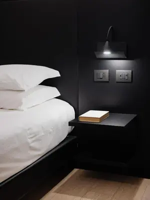 a black bedroom with a bed and a book on a table at Dream Suite Trevi in Rome