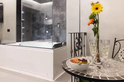 a table with a bowl of fruit and a vase with a flower at Dream Suite Trevi in Rome