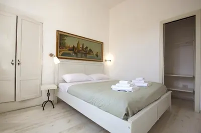 a white bedroom with a bed with towels on it at Testaccio View Holiday House in Rome