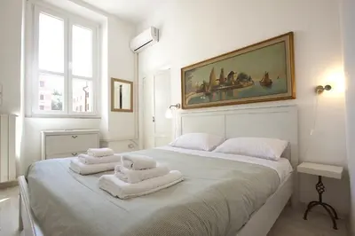 a white bedroom with two towels on a bed at Testaccio View Holiday House in Rome