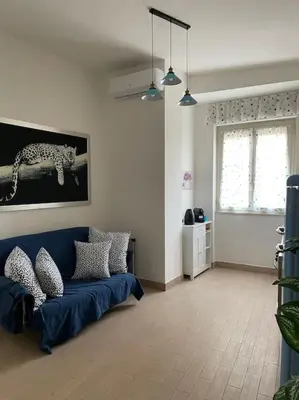 a living room with a blue couch and a window at casa celeste, Roma in Rome