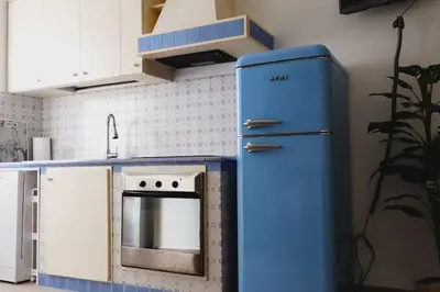 a blue refrigerator in a kitchen next to a stove at casa celeste, Roma in Rome