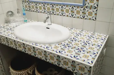 a bathroom sink with a counter top with flowers on it at casa celeste, Roma in Rome