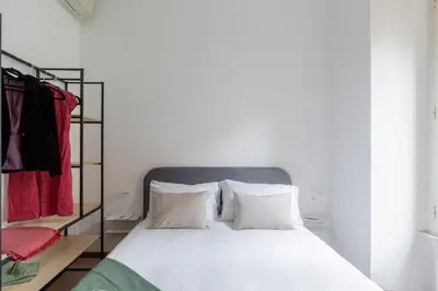 a bedroom with a bed and a rack of clothes at iFlat Comfortable Apartment next to the Vatican in Rome