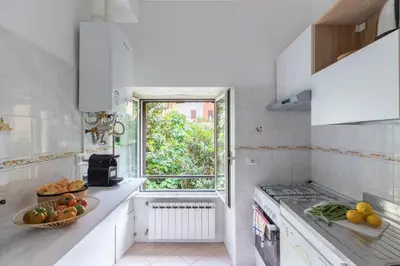 a white kitchen with a sink and a window at iFlat Comfortable Apartment next to the Vatican in Rome