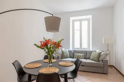 a living room with a couch and a table and chairs at iFlat Comfortable Apartment next to the Vatican in Rome