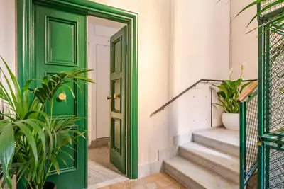 a green door in a hallway with plants at Roma private rooms Vatican City in Rome
