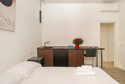 a bedroom with a bed and a desk with a sink at Roma private rooms Vatican City in Rome