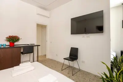 a room with a desk and a television on a wall at Roma private rooms Vatican City in Rome