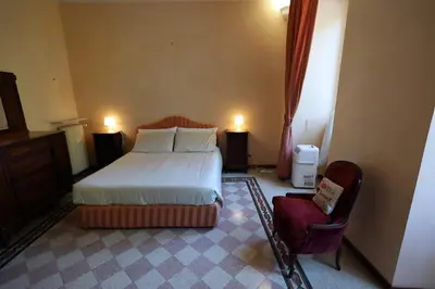 a bedroom with a bed and a chair and two lights at Casa Salimei in Rome