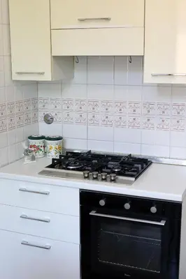 a kitchen with a stove and white cabinets at Casa Salimei in Rome