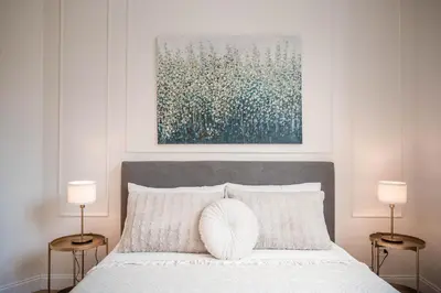 a bedroom with a bed with two lamps and a painting at Appartamento San Giovanni fino a 6 persone in Rome