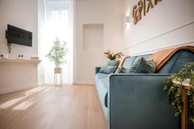 a living room with a blue couch and a wooden floor at Appartamento San Giovanni fino a 6 persone in Rome